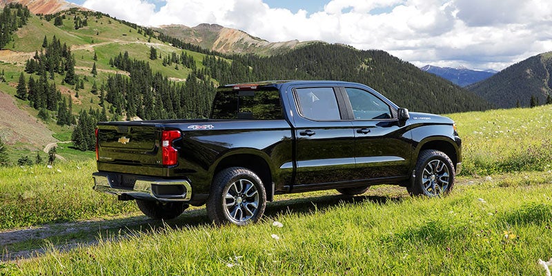 Chevrolet Silverado 1500 parked in a scenic green mountain landscape.